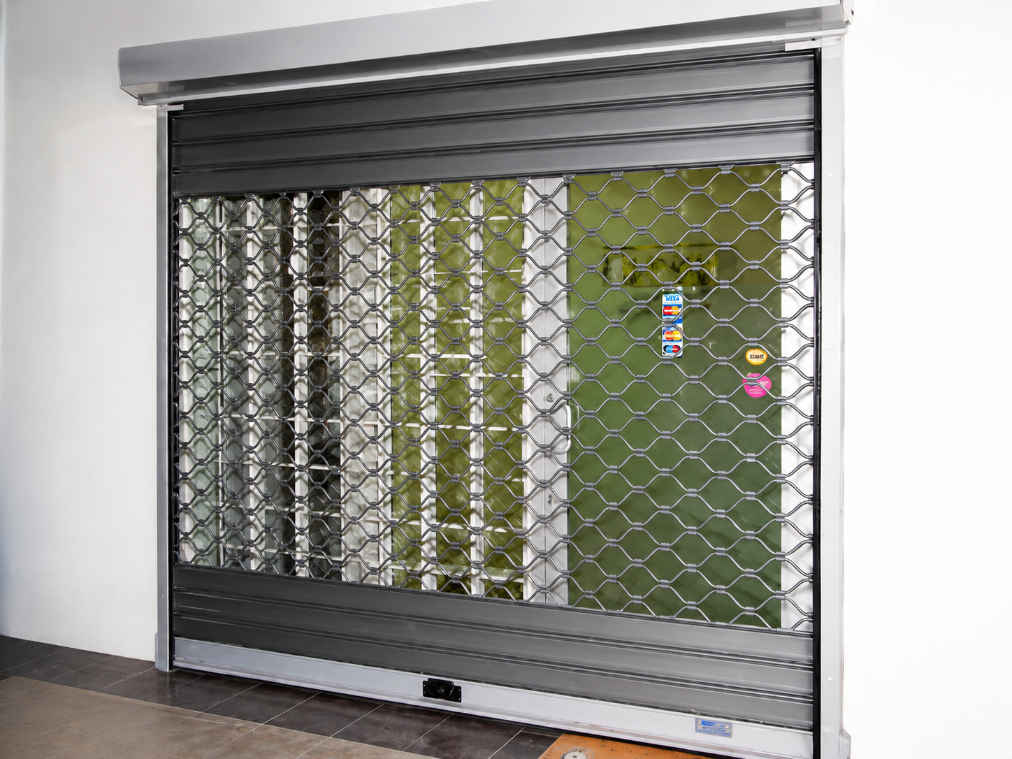 Mesh shutter installed at commercial entrance — front elevation view